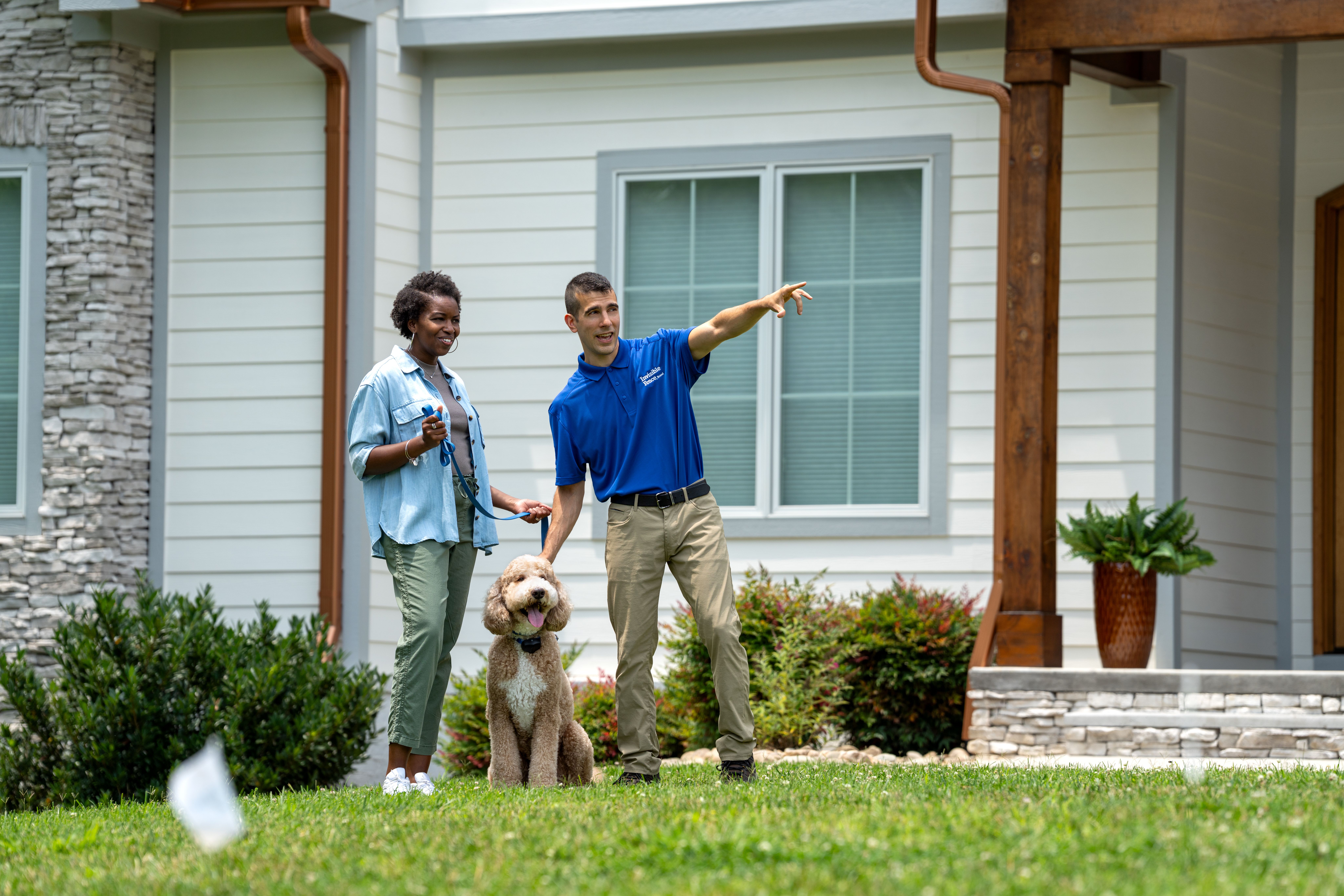 Invisible Fence trainer showing a customer and their dog the new boundary.