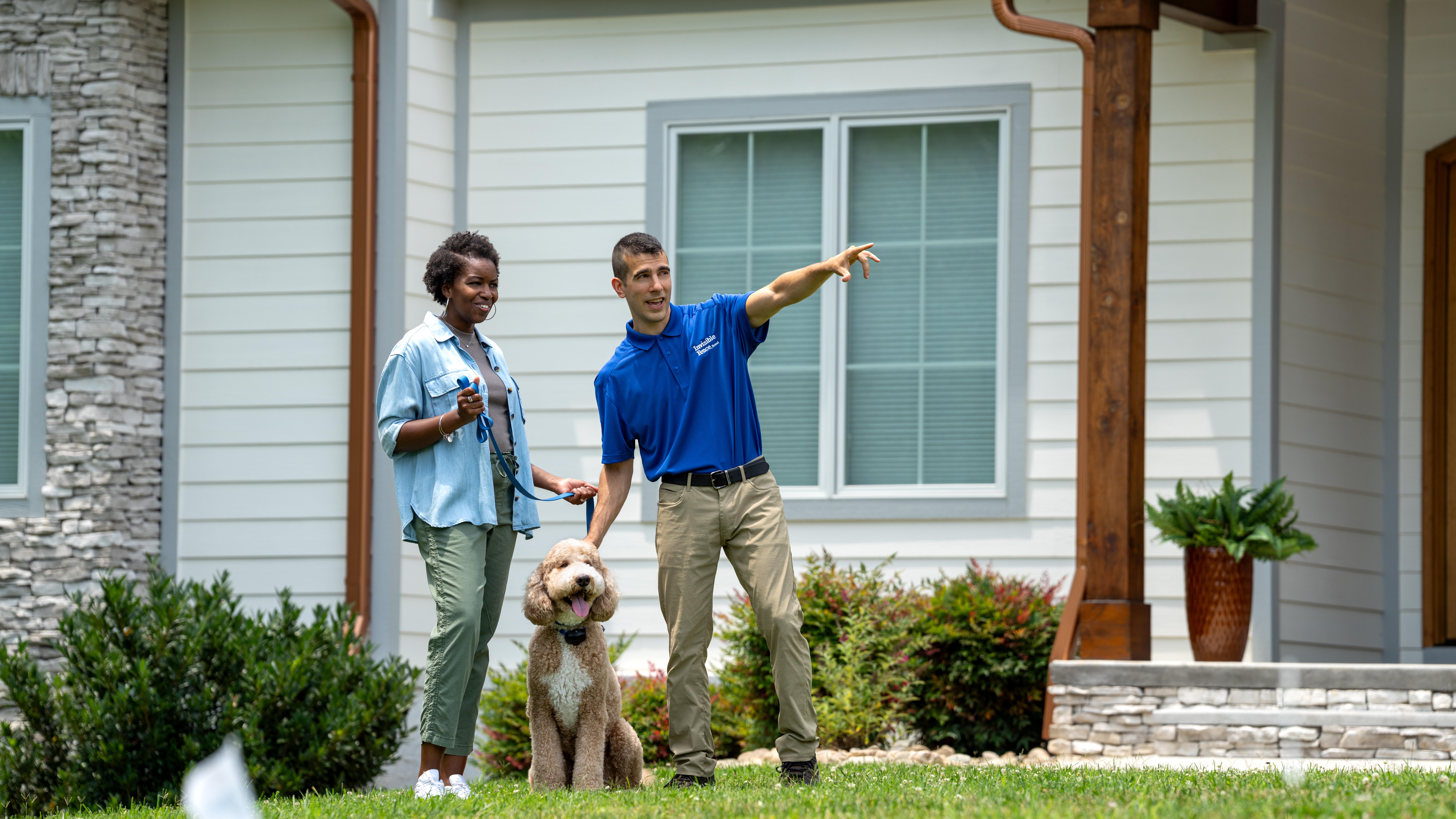 Invisible Fence trainer showing a customer and their dog the new boundary.