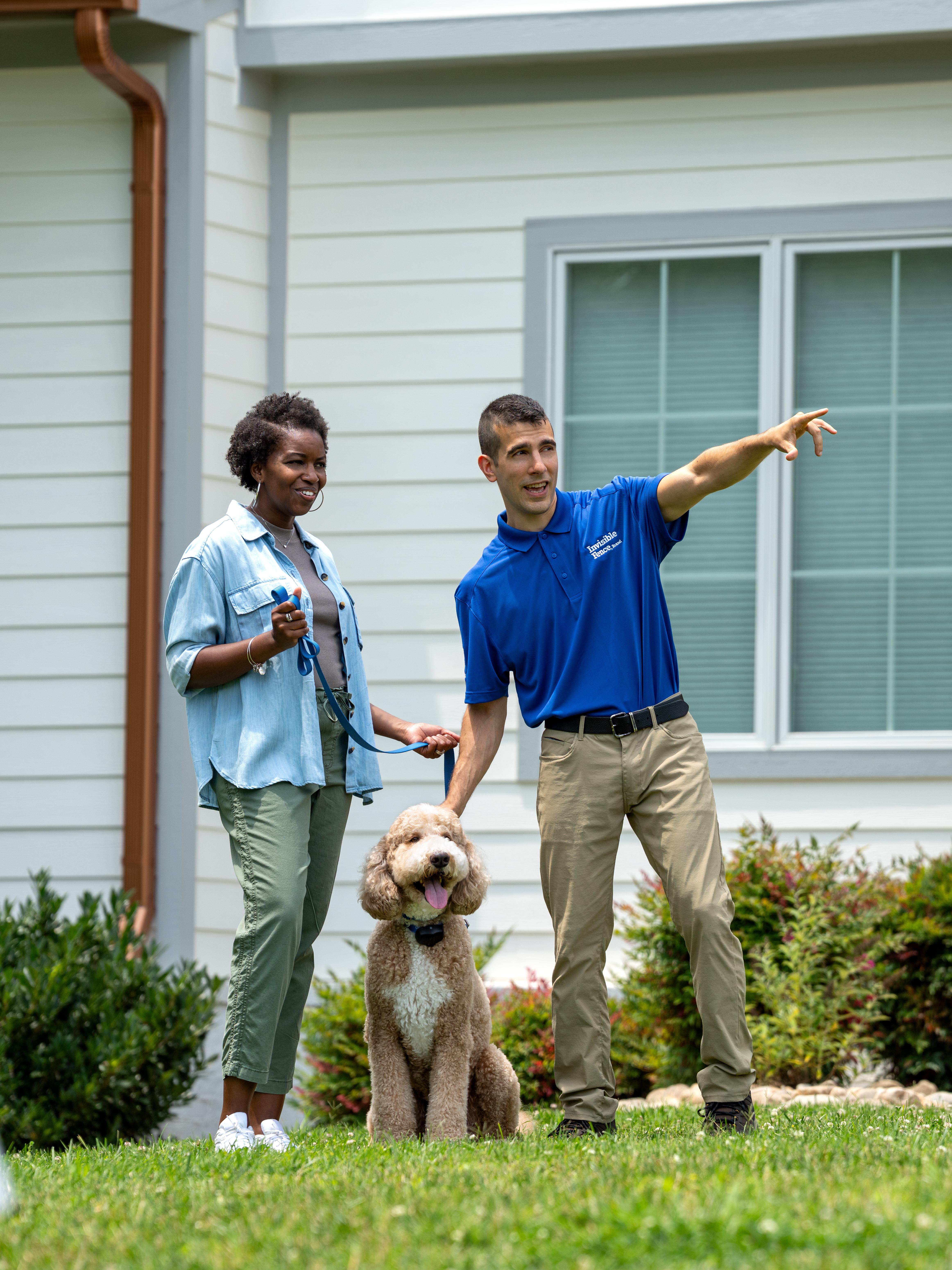 Invisible Fence trainer showing a customer and their dog the new boundary.