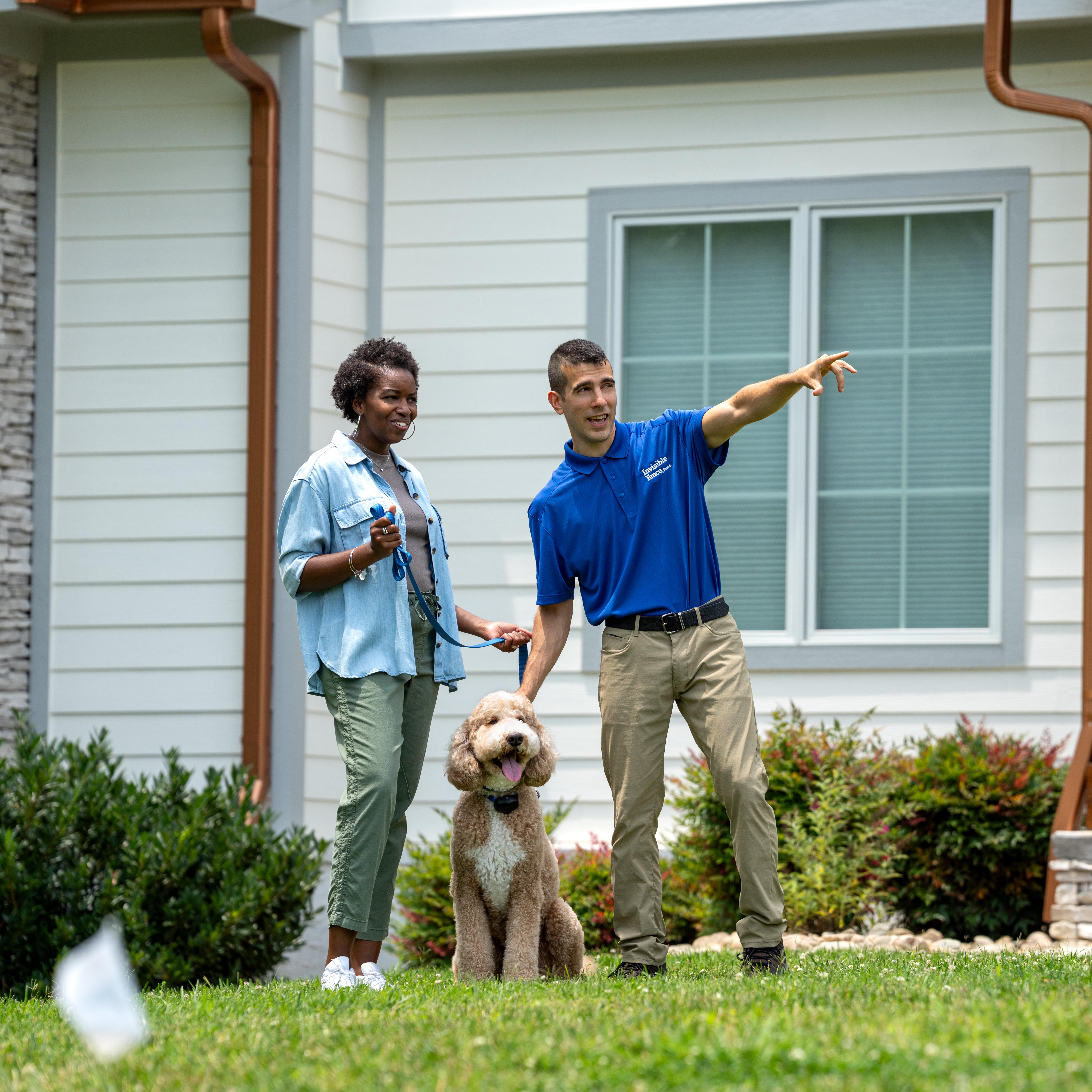 Invisible Fence trainer showing a customer and their dog the new boundary.