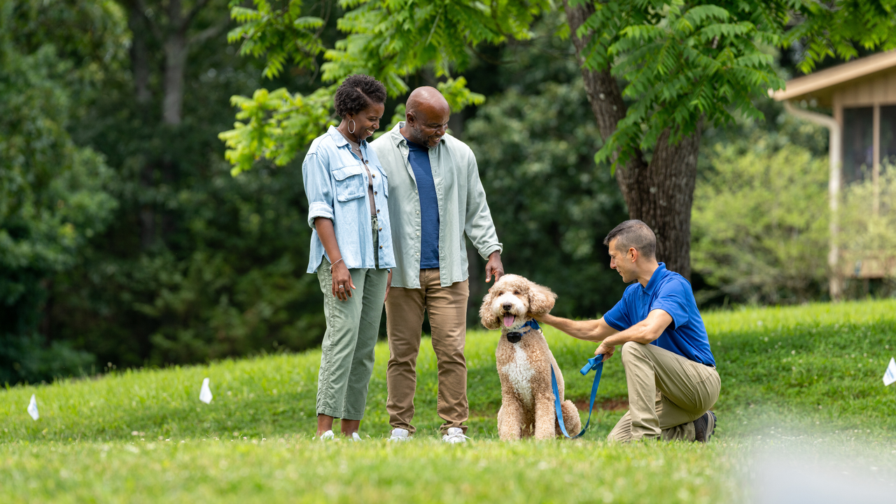 invisible fence trainer working with a dog and its owner