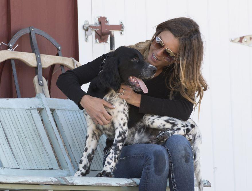 Woman and dog wearing SportDOG collar sitting on bench