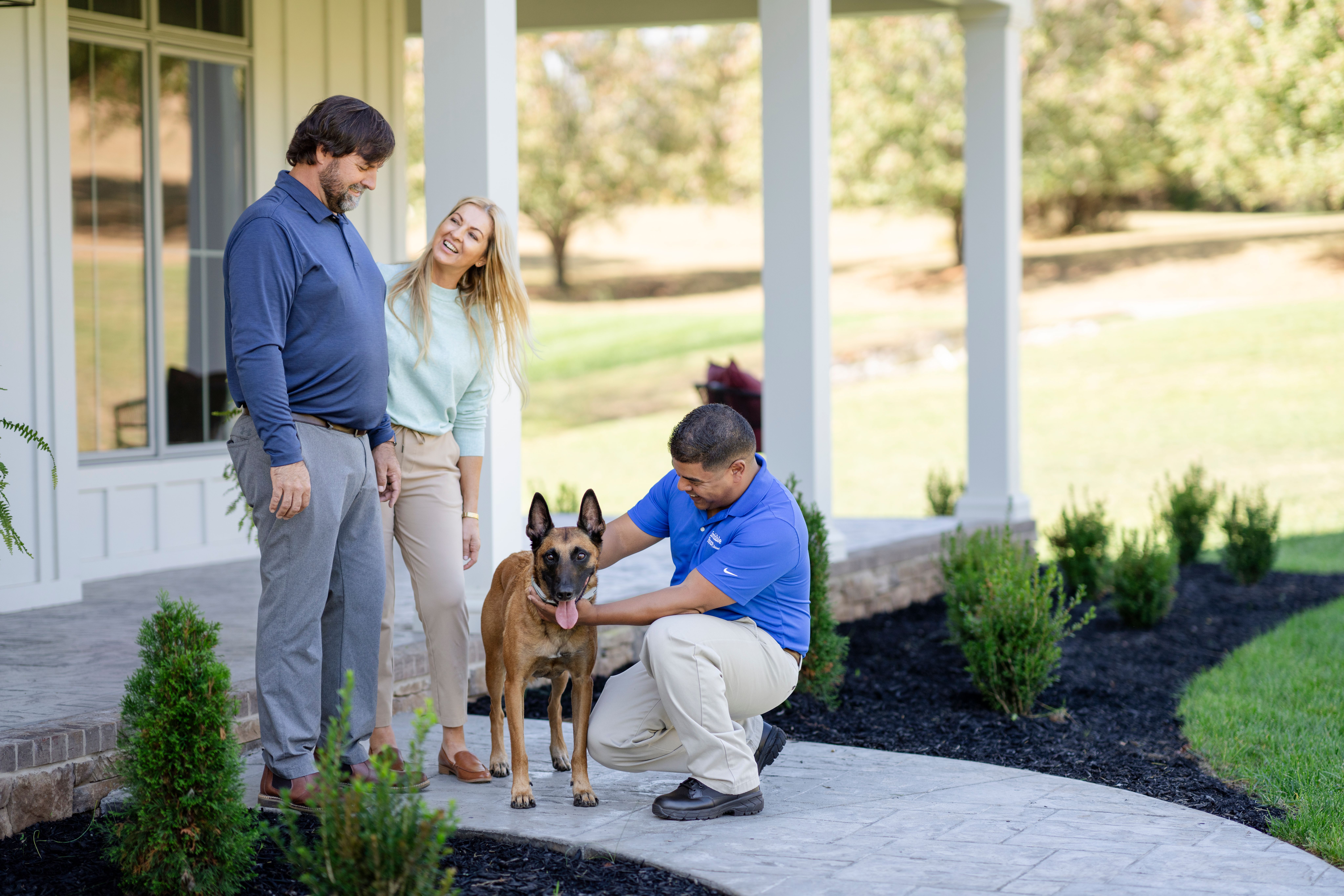 shepherd stands with invisible fence trainer and owners while being fitted for a invisible fence gps dog collar