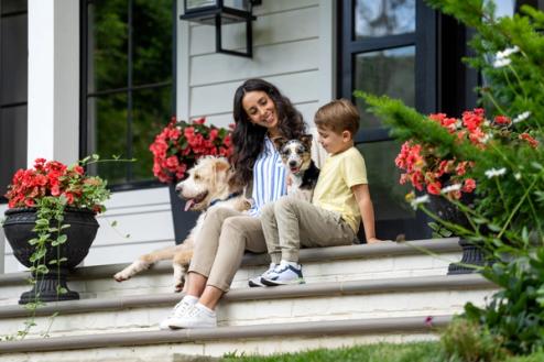 mother and son sitting on front porch with two dogs