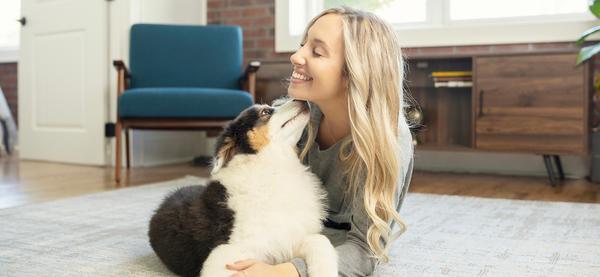 Woman laying in floor with puppy