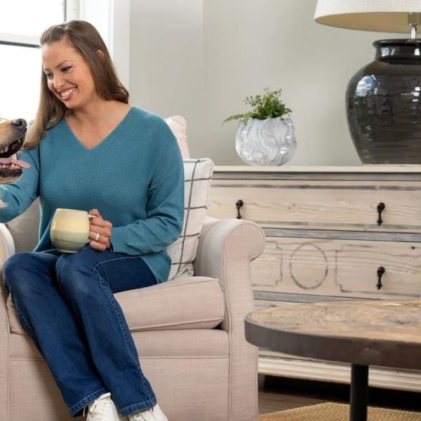 Woman sitting, drinking coffee and petting Golden Retriever