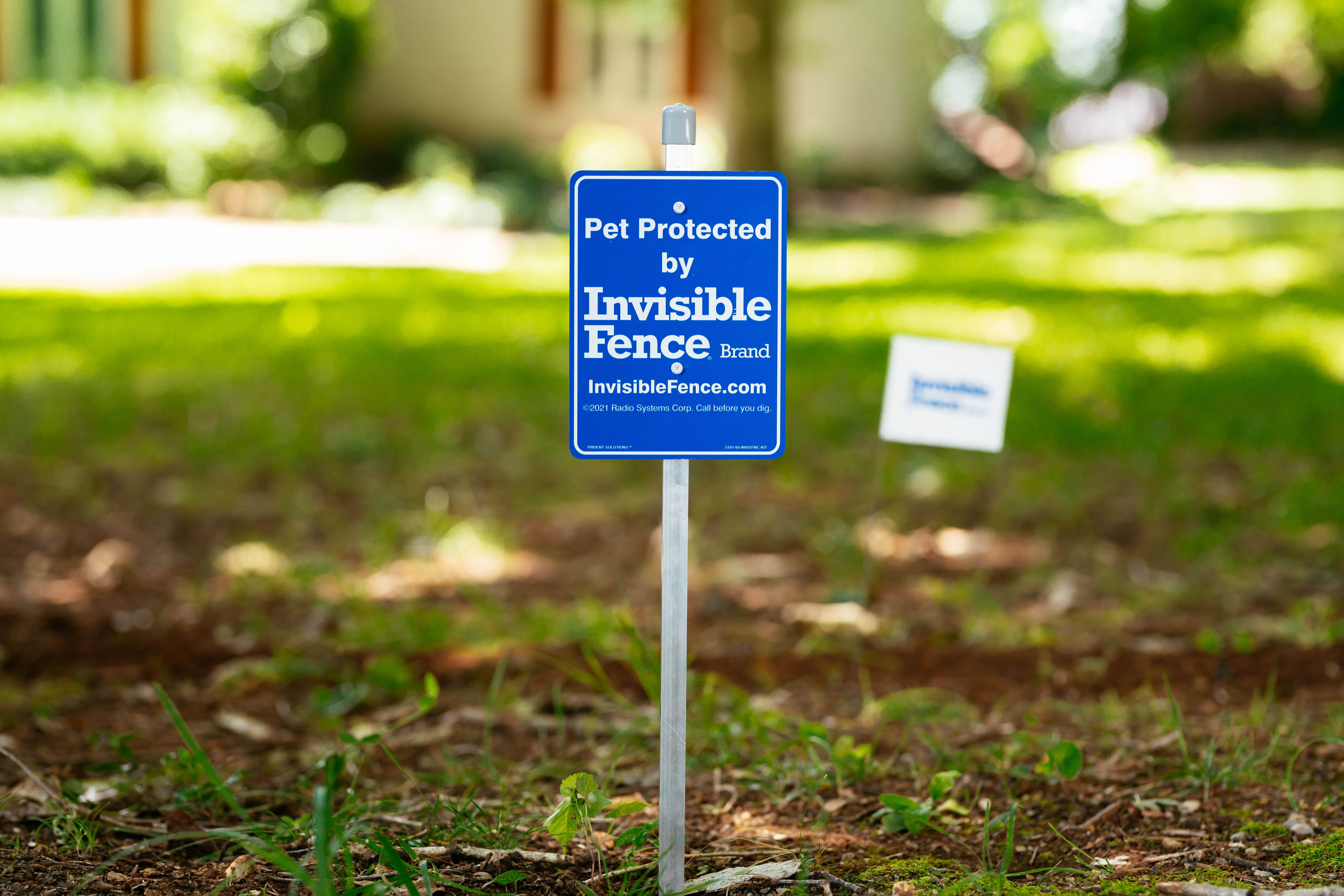 Pet Protected by Invisible Fence Brand sign in front yard. 