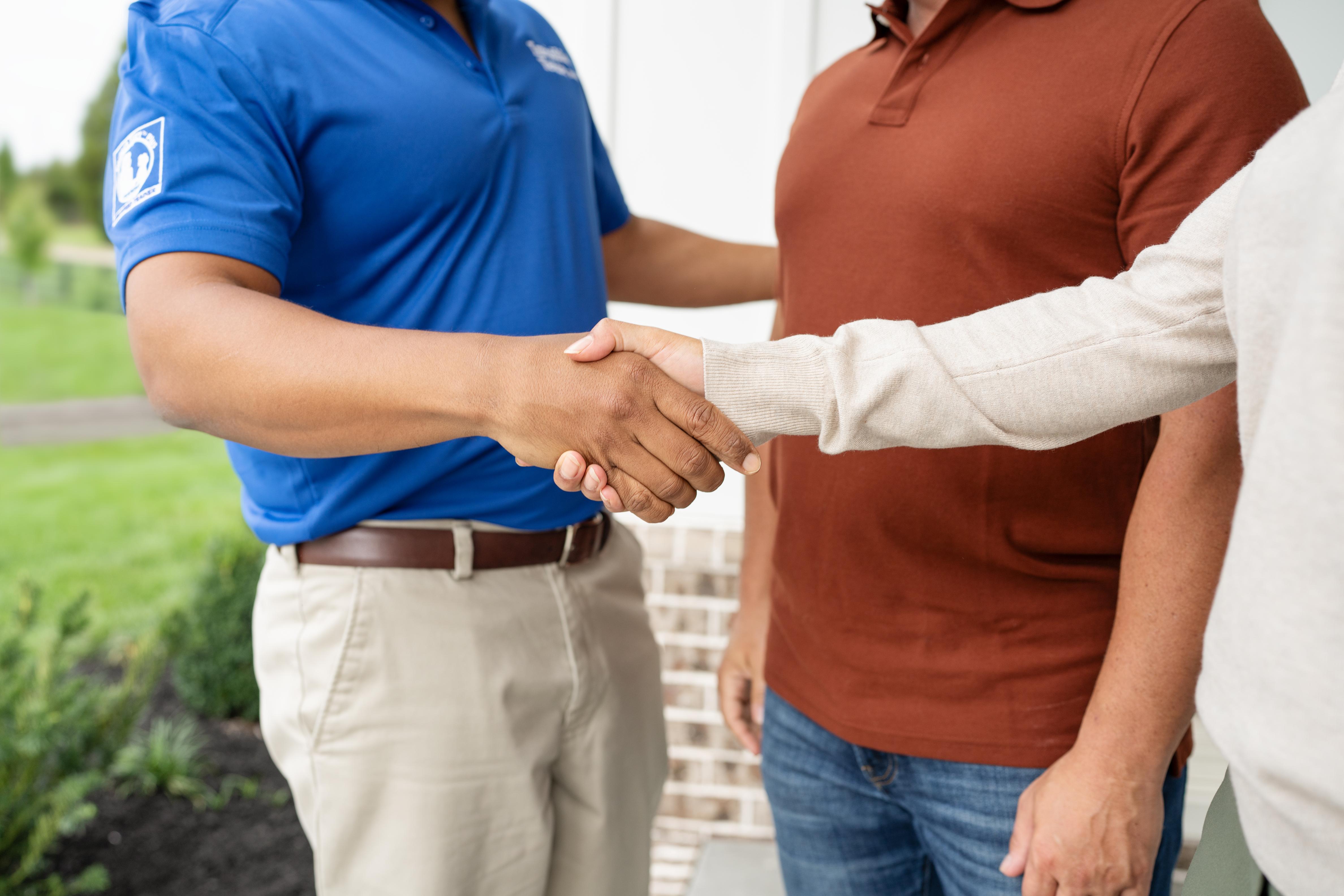 An invisible fence trainer shaking owners hands