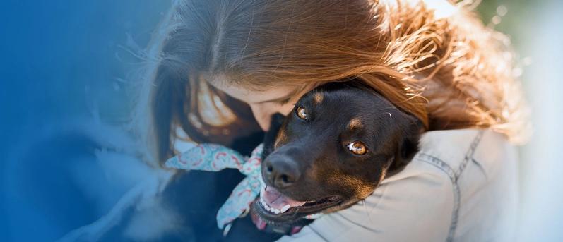 Girl hugging dog.