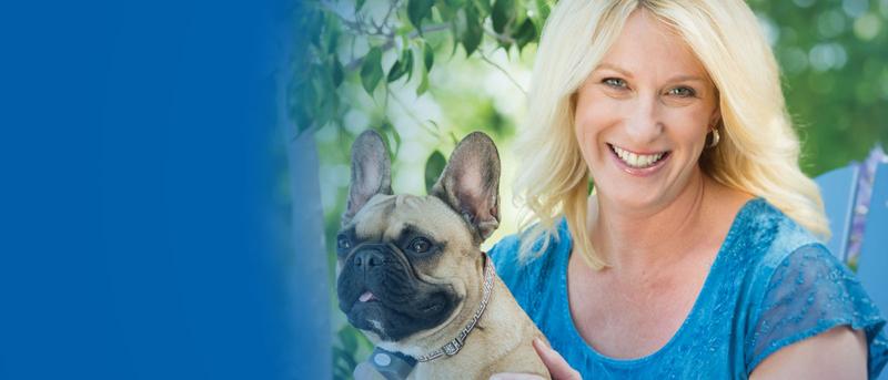Woman sits with French Bulldog wearing Invisible Fence Brand dog collar.
