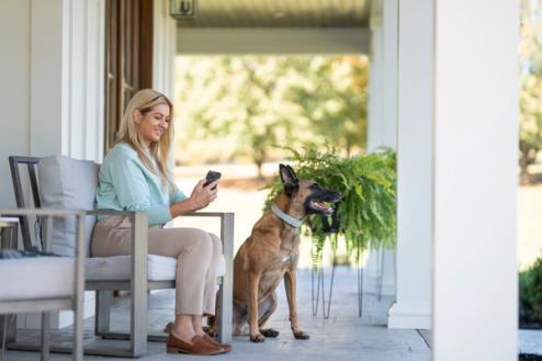 woman sits on porch with Belgian malinois wearing invisible fence gps collar