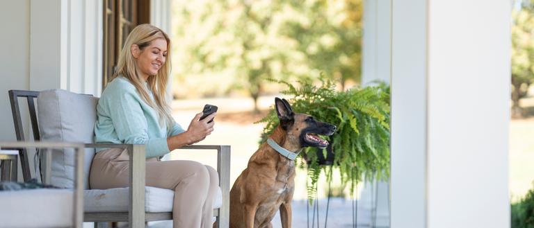 woman sits on porch with Belgian malinois wearing invisible fence gps collar