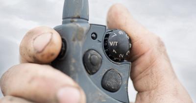 a dog training remote held in someone's hand