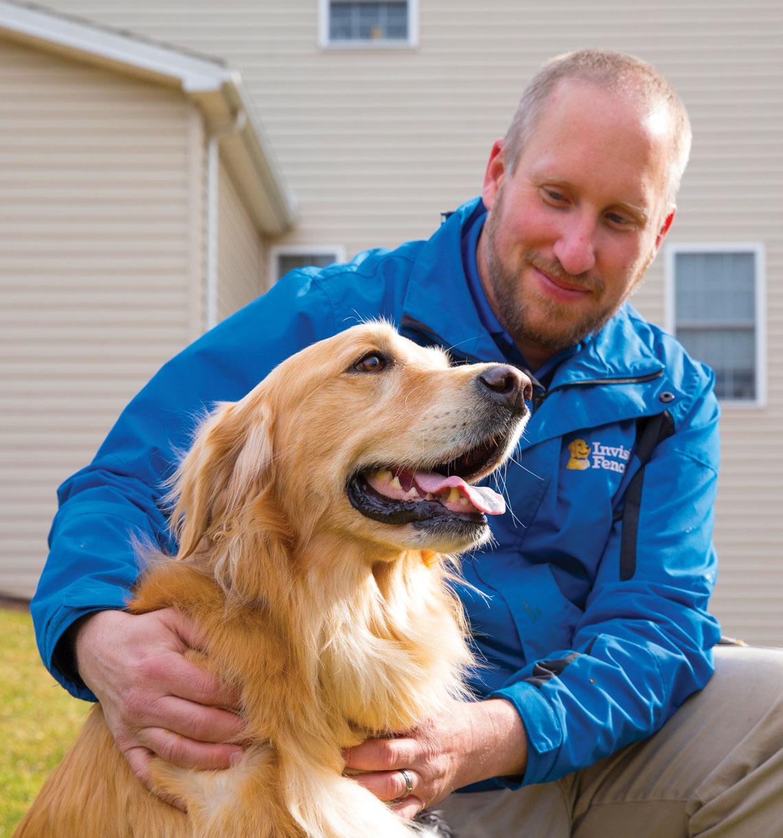 Invisible Fence dealer petting dog in backyard. 