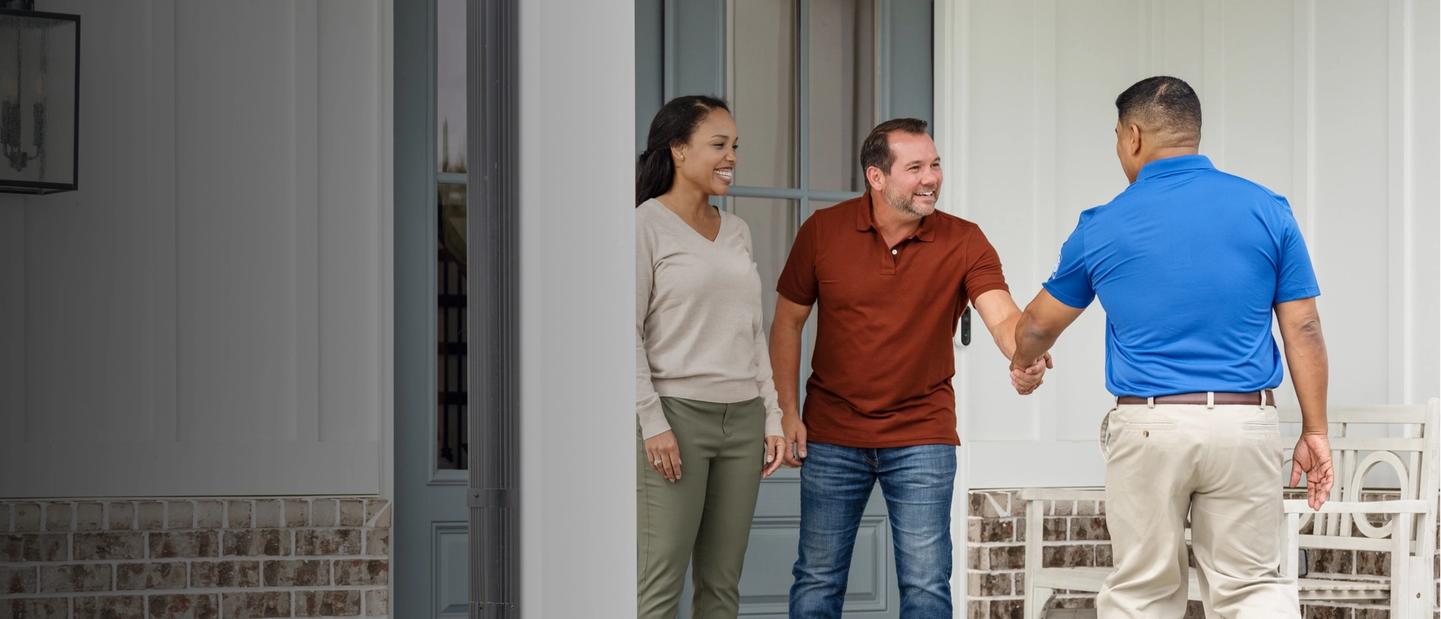 Wife and husband greet Invisible Fence professional outside of home.