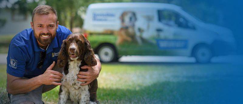 Invisible Fence Pet Consultant with dog with van in background.