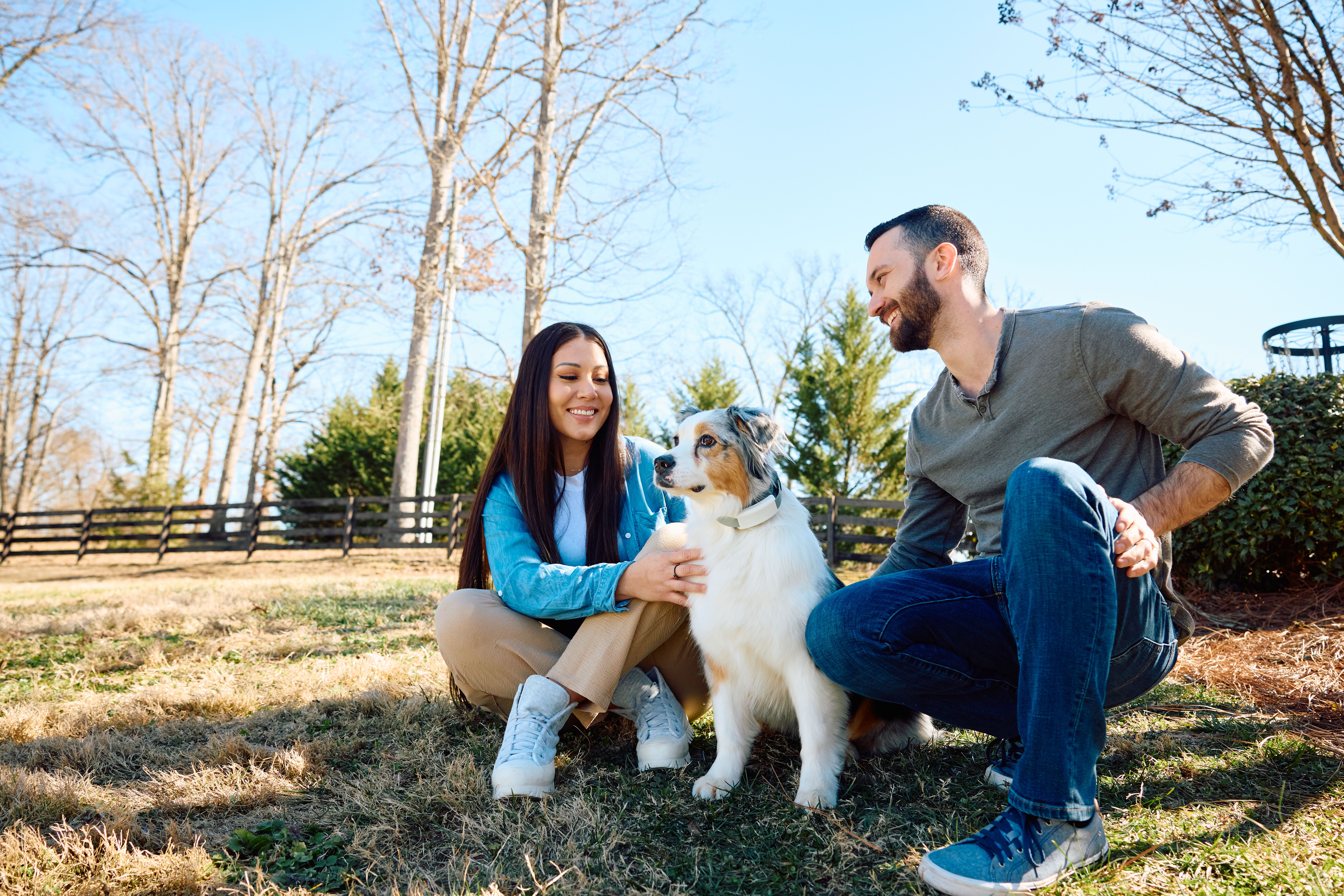 Husband and wife enjoying outdoors with their dog off-leash