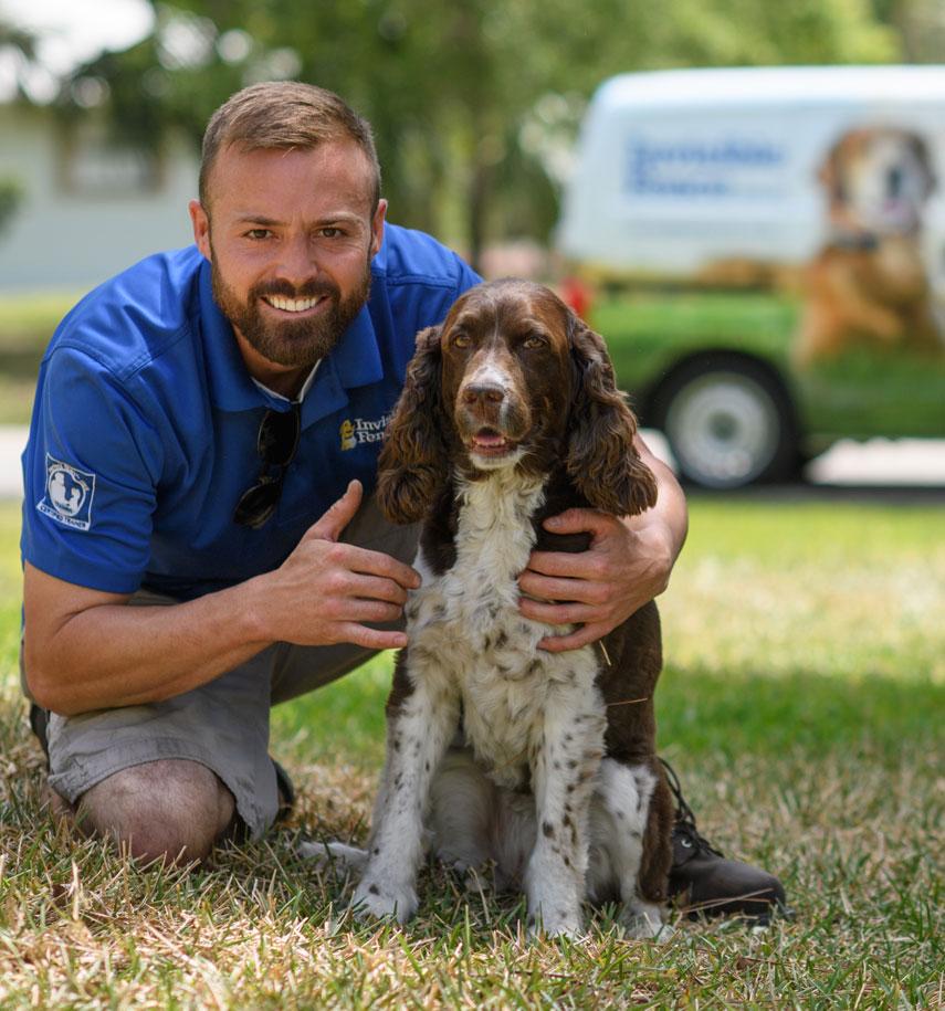 Invisible Fence Brand trainer sitting with dog outside