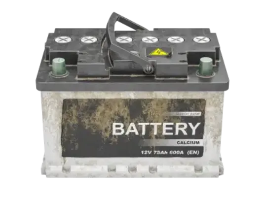 Used car battery with a worn appearance. The battery is rectangular with a black top and a gray body, featuring a carrying handle on top. The label on the front reads "BATTERY" in large letters, with specifications "12V 75Ah 600A (EN)" underneath. The surface of the battery is dirty, with signs of grime and wear.