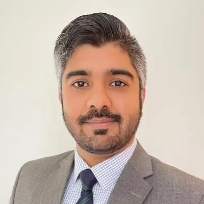 Bilal Bhatti, Working Student Data Analyst for METYCLE; person wearing a light gray suit with a light blue shirt and a dark gray tie, slightly smiling directly to the camera, with gray hair parted to the left side and a beard