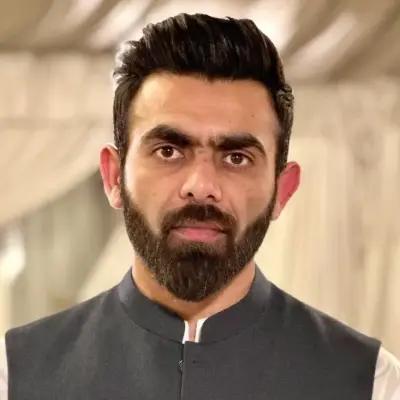 Sufyan Afzal, Senior Backend Engineer for METYCLE; person wearing a dark gray suit, in front of a beige background, looking directly at the camera, with short black hair and a beard