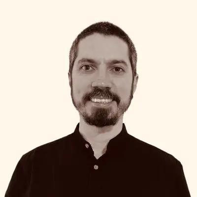 Higor Rossato, Senior Backend Engineer for METYCLE; person wearing a black button down shirt, in front of a beige background, smiling and looking directly to the camera, with a beard and short dark hair
