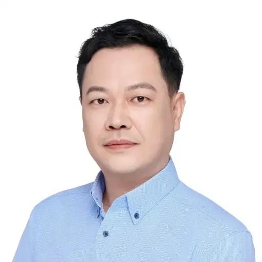 Harry Wang, Head of Business Development and Trading; person wearing a light blue button down shirt in front of a white background, with short straight dark hair and looking directly to the camera