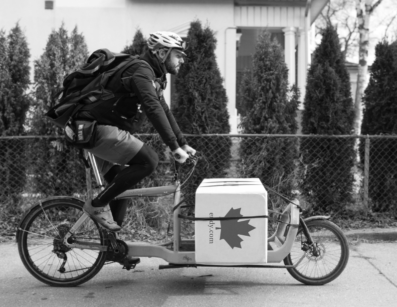 Man on a bicycle delivering an Endy Mattress box