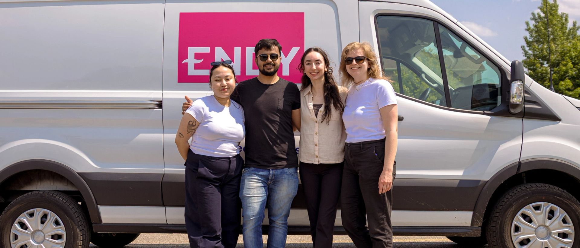 4 people standing in front of a white van with Endy branding