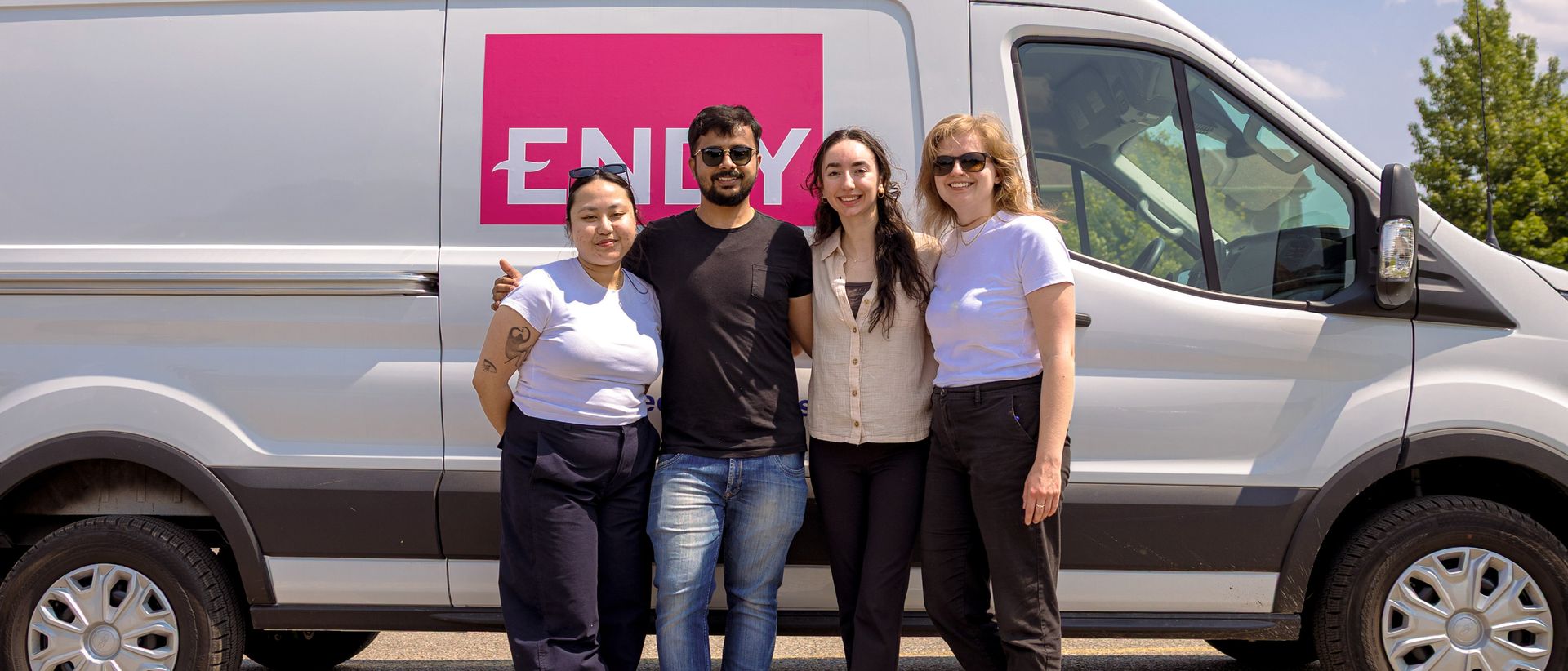 4 people standing in front of a white van with Endy branding