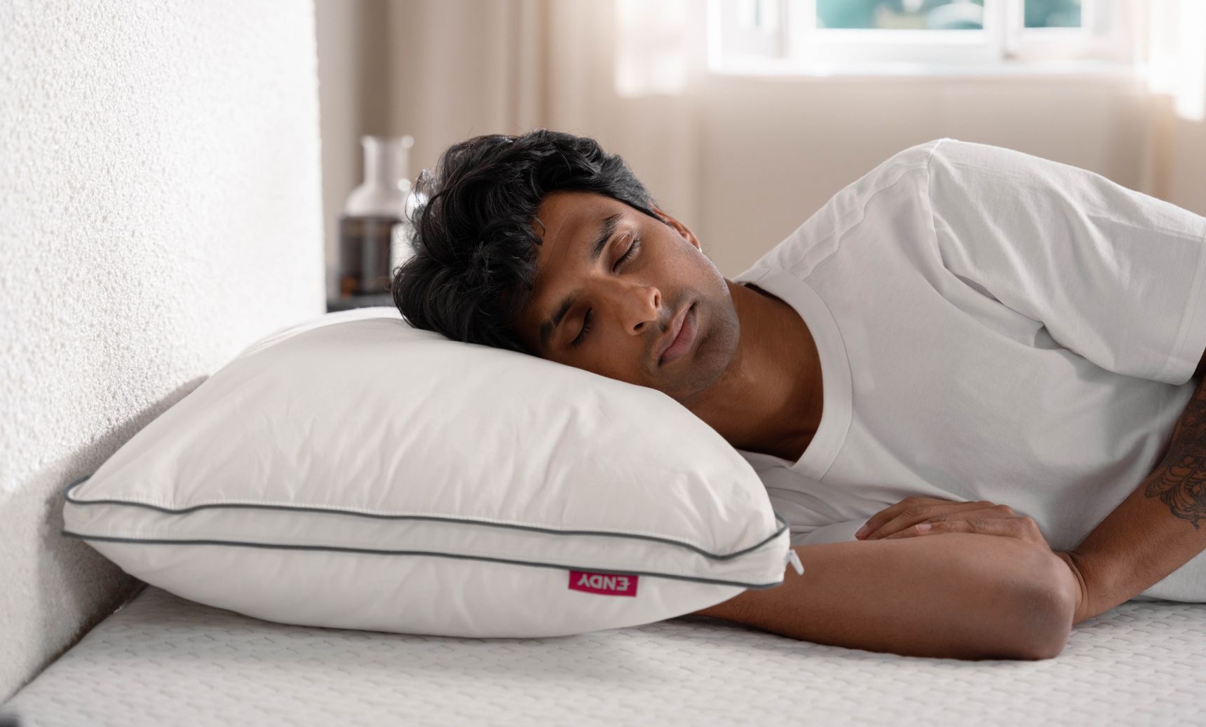 Man side sleeping with an Endy Customizable Pillow under his head