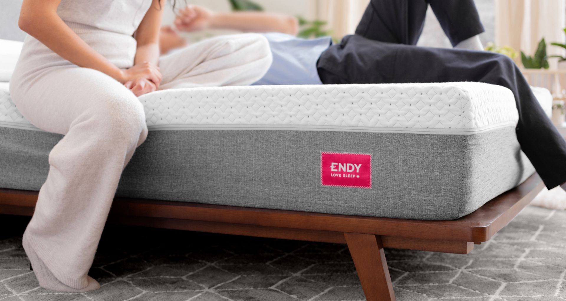 Two people relaxing on an Endy Mattress on an Endy Solid Wood Bed.