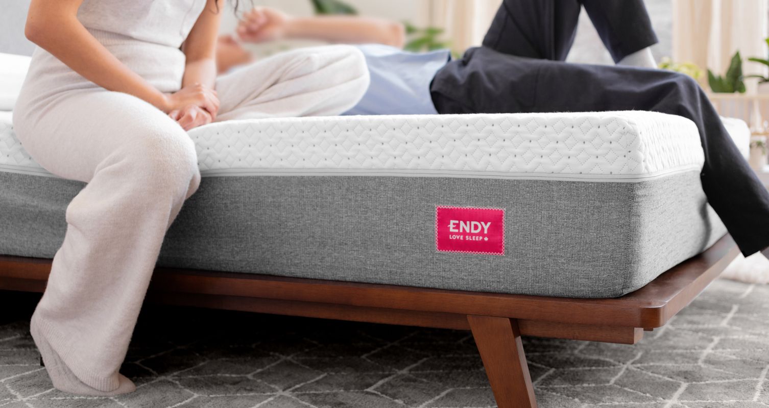 Two people relaxing on an Endy Mattress on an Endy Solid Wood Bed.