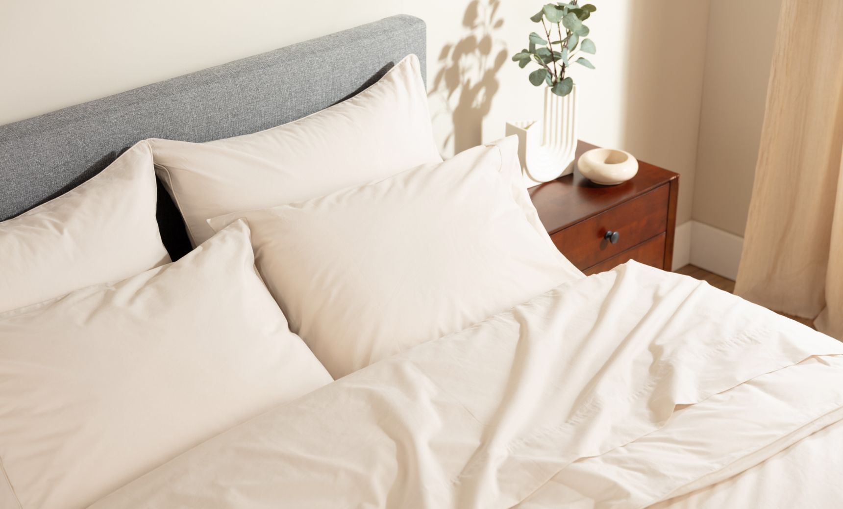 Bed with cream sheets and pillows