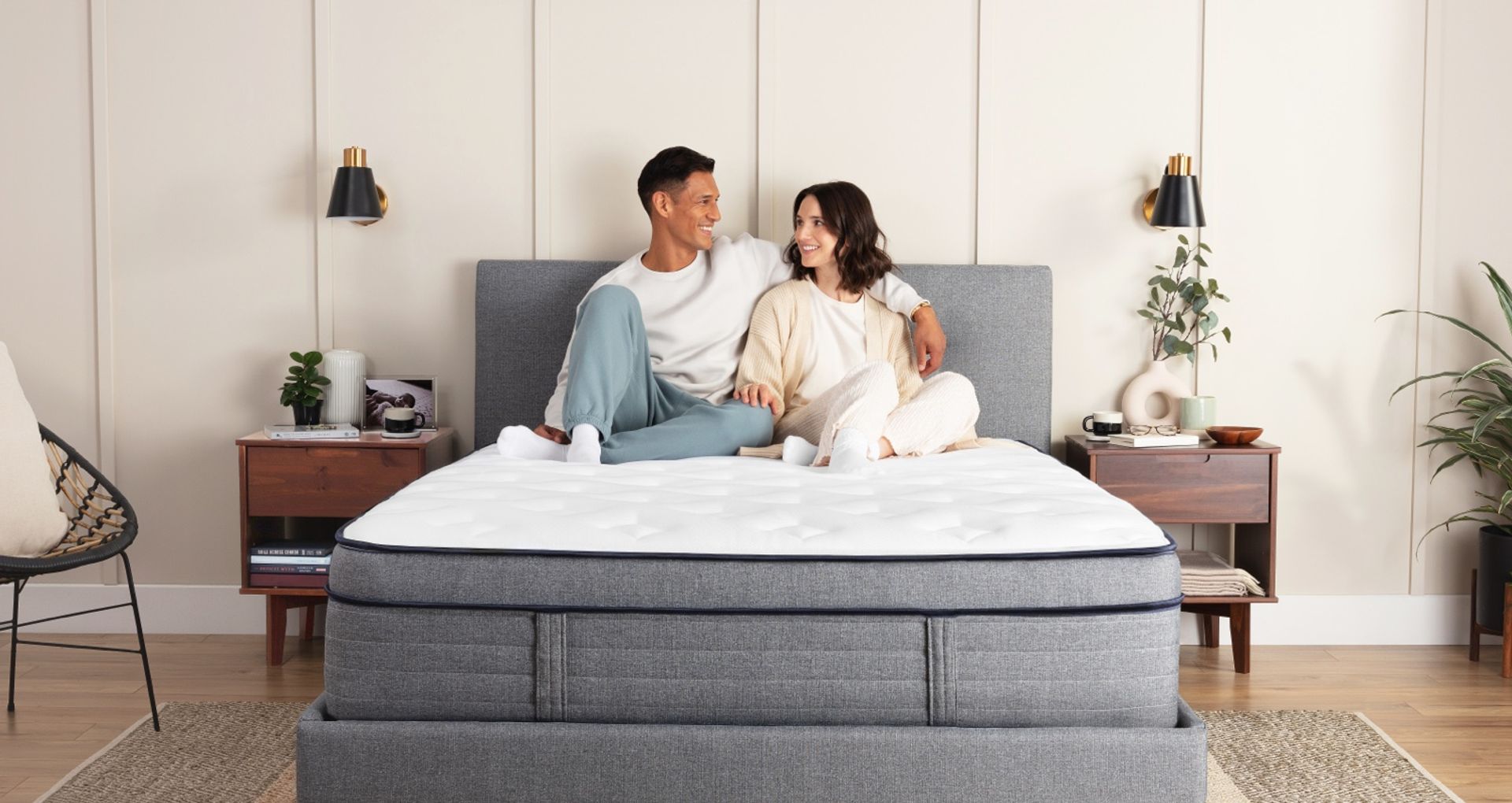A man and woman sitting on an Endy Hybrid Mattress.