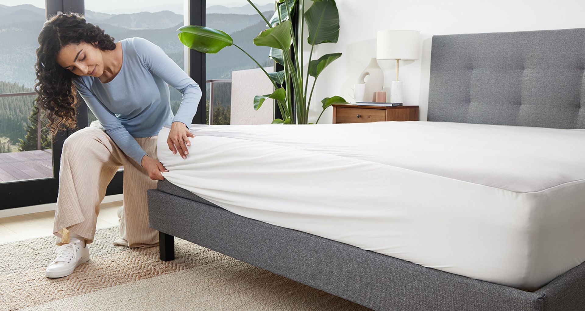  Woman putting on Endy’s Mattress Protector on her Endy Mattress