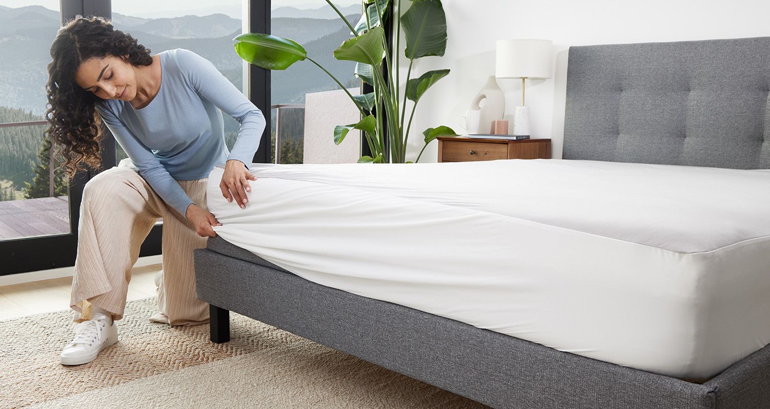 Woman putting on Endy’s Mattress Protector on her Endy Mattress