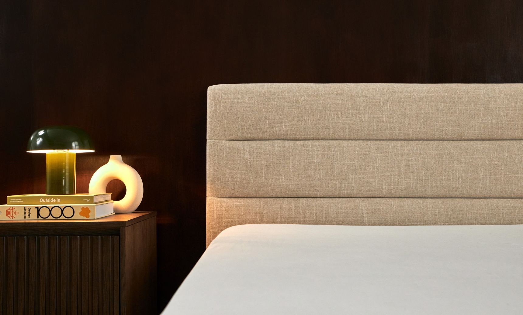 Bedroom with channel upholstered bed frame in alabaster colourway, shown with wooden nightstand.