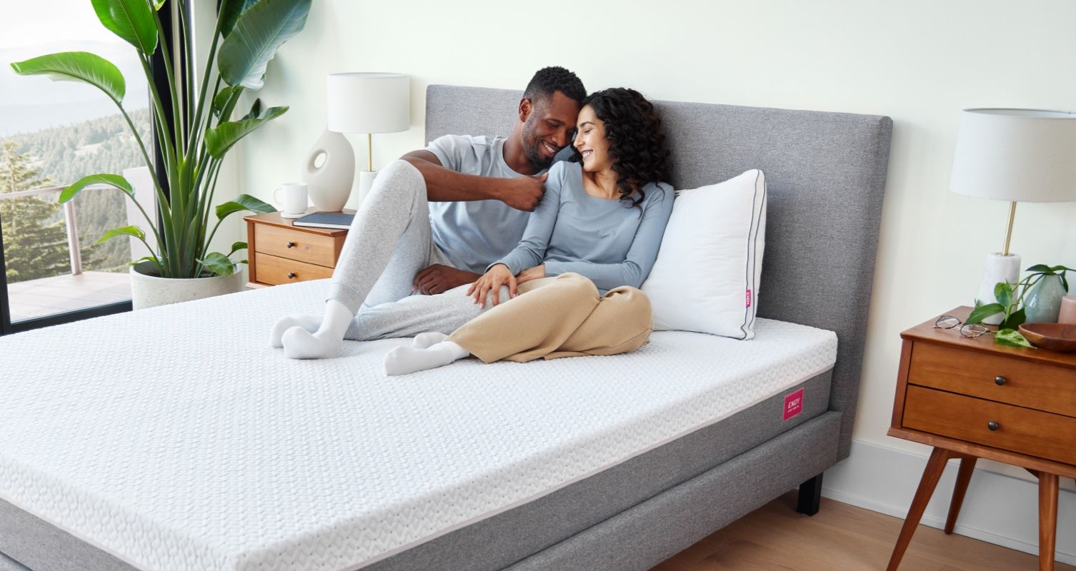 A man and woman sitting on an Endy Mattress.