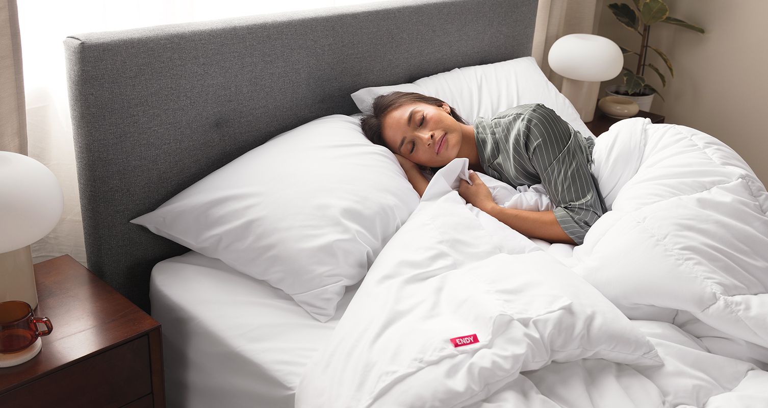 Image of a woman sleeping in bed wrapped in an Endy duvet