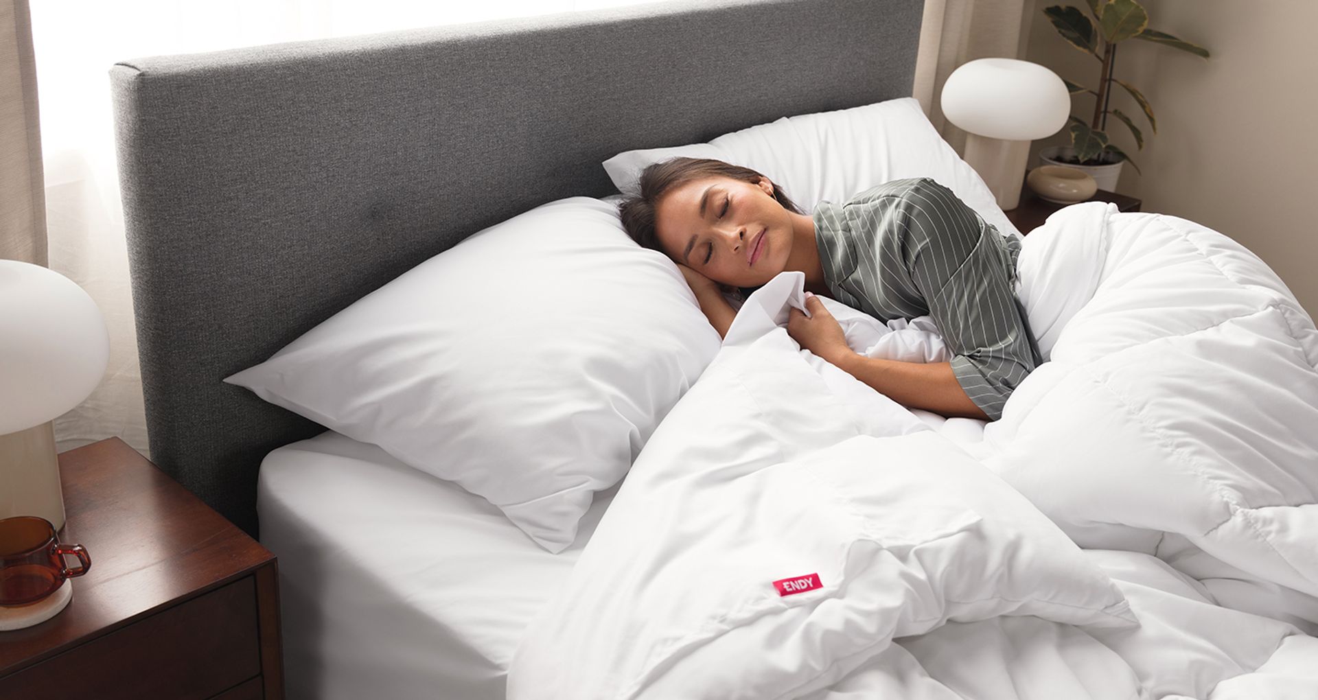 Image of a woman sleeping in bed wrapped in an Endy duvet