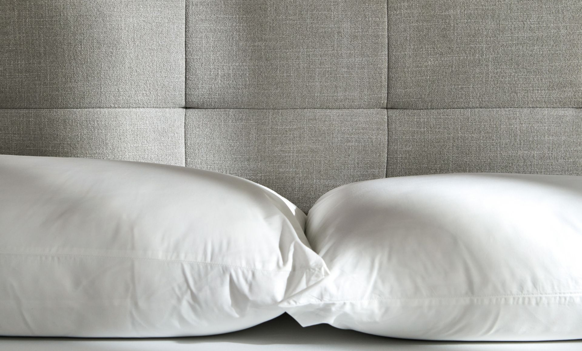 Bedroom featuring the tufted upholstered bed frame in ash grey with the wooden nightstand.