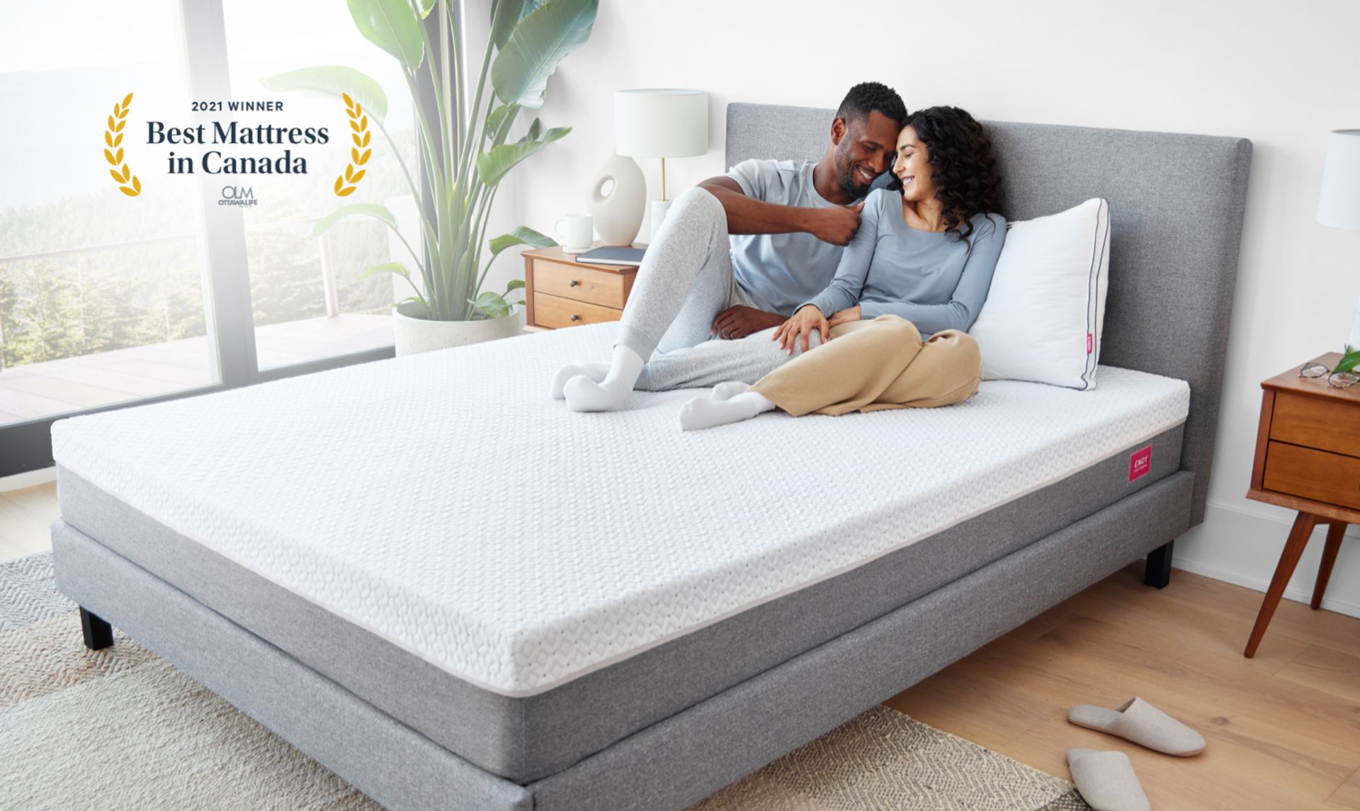 Two people relaxing in a bedroom outfitted with Endy's collections of sleep products.