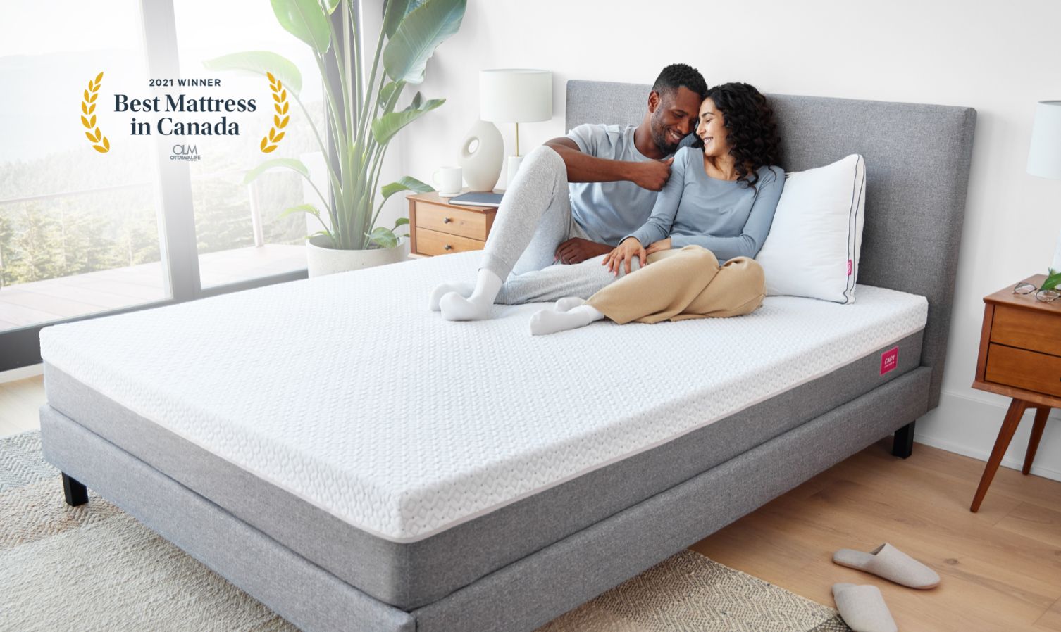 Two people relaxing in a bedroom outfitted with Endy's collections of sleep products.