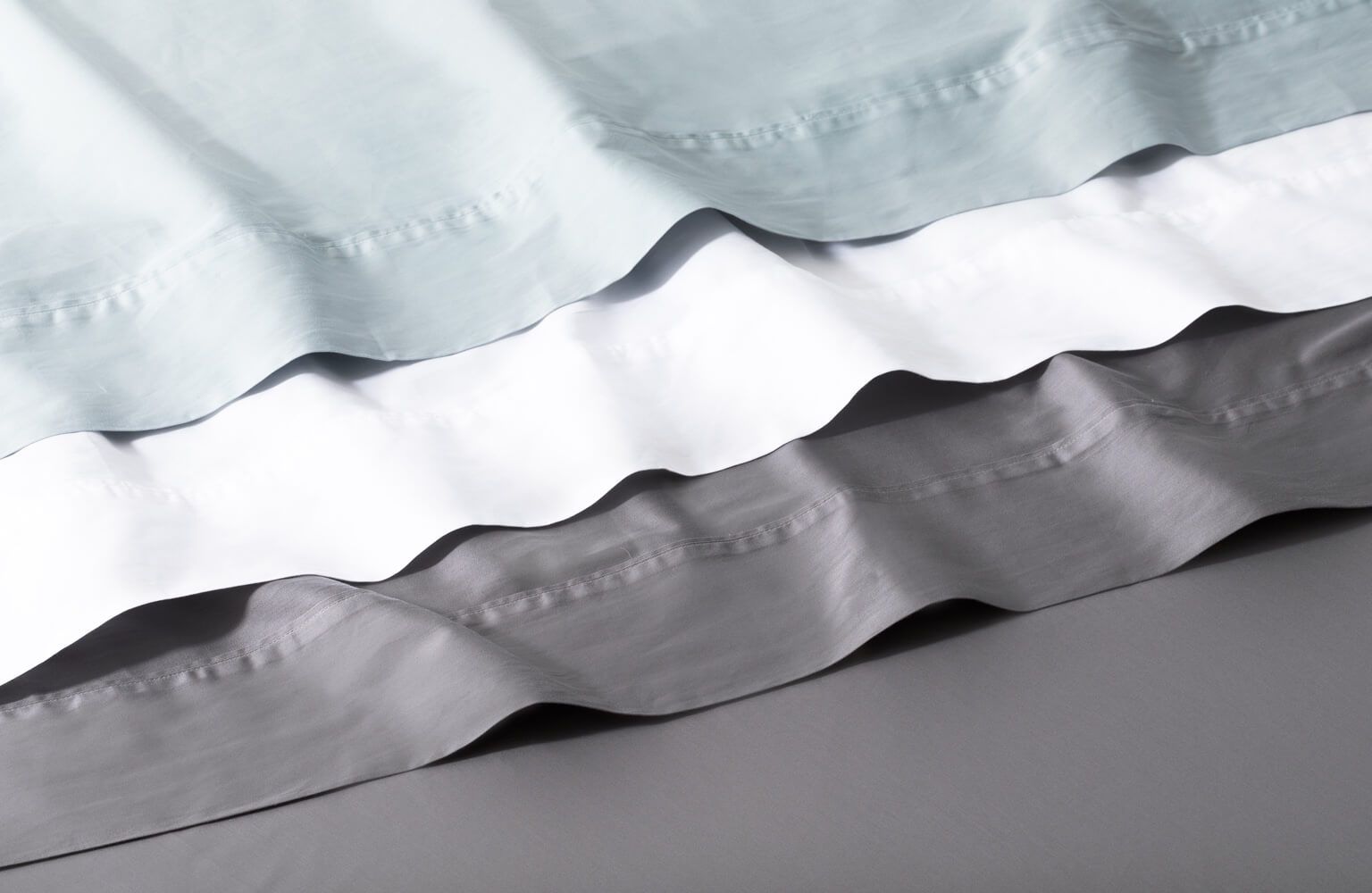 The Organic Cotton Sheet Set is available in three colours: Glacier Blue, Alpine White, Storm Grey.