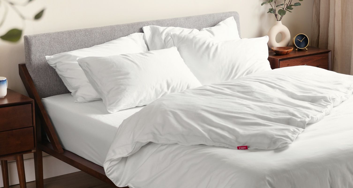 An Endy Solid Wood Bed made up with Endy bedding in Alpine White, with the Endy Duvet folded down.