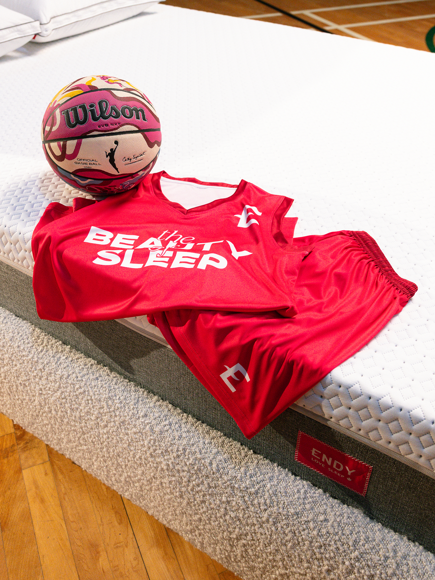 Custom Endy x WNBA basketball on an Endy Mattress with an Endy "Beauty of Sleep" basketball uniform draped on it