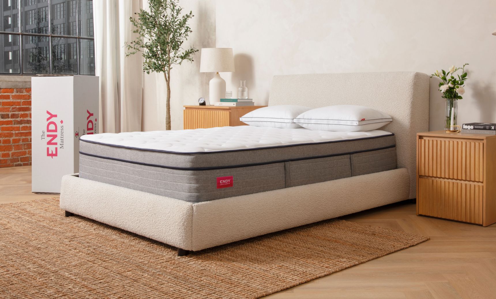 Bare Endy Hybrid mattress on a white upholstered bed frame in a beige bedroom