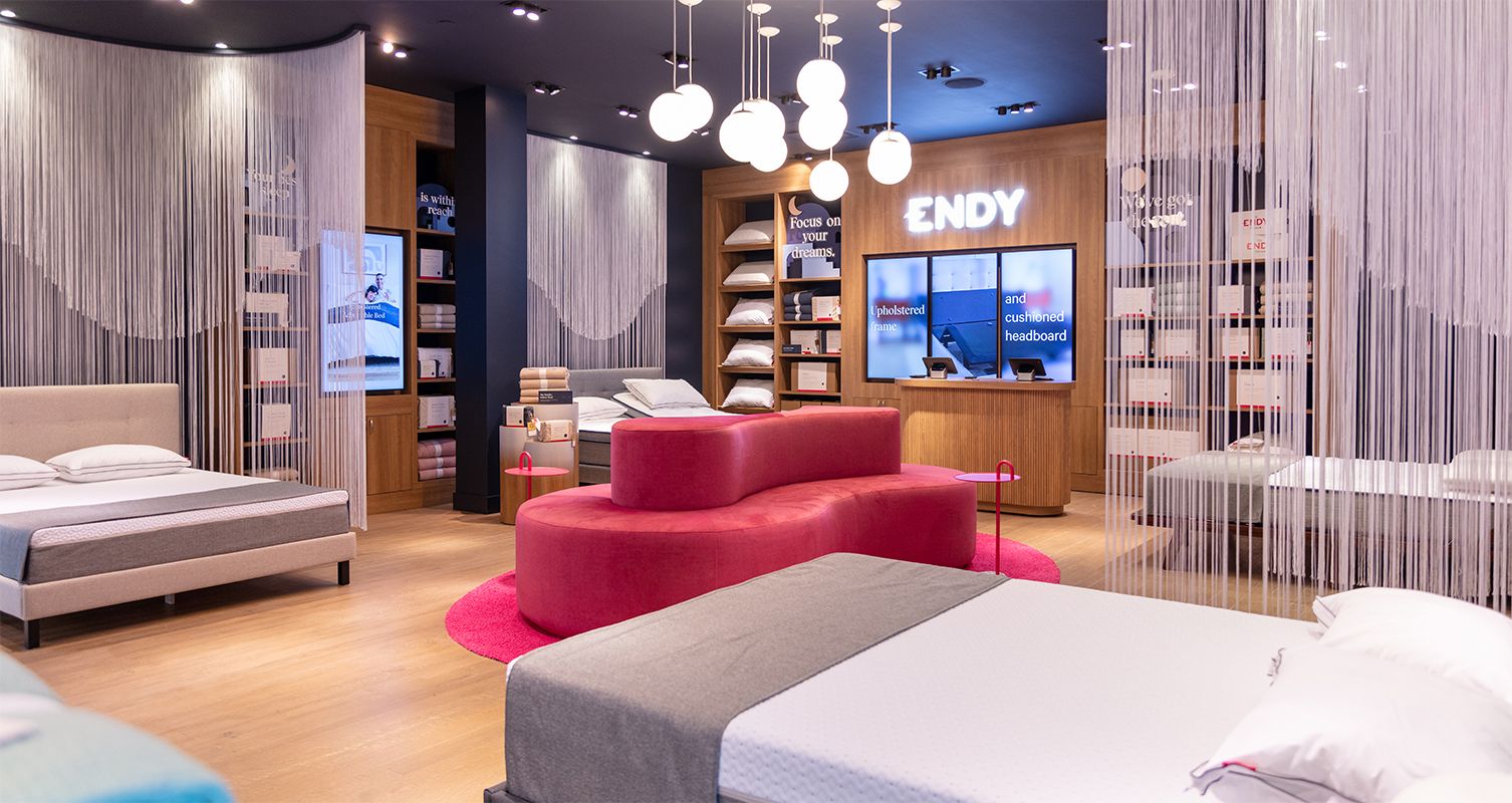 Inside of the Endy store, featuring beds, product shelves and a large pink couch