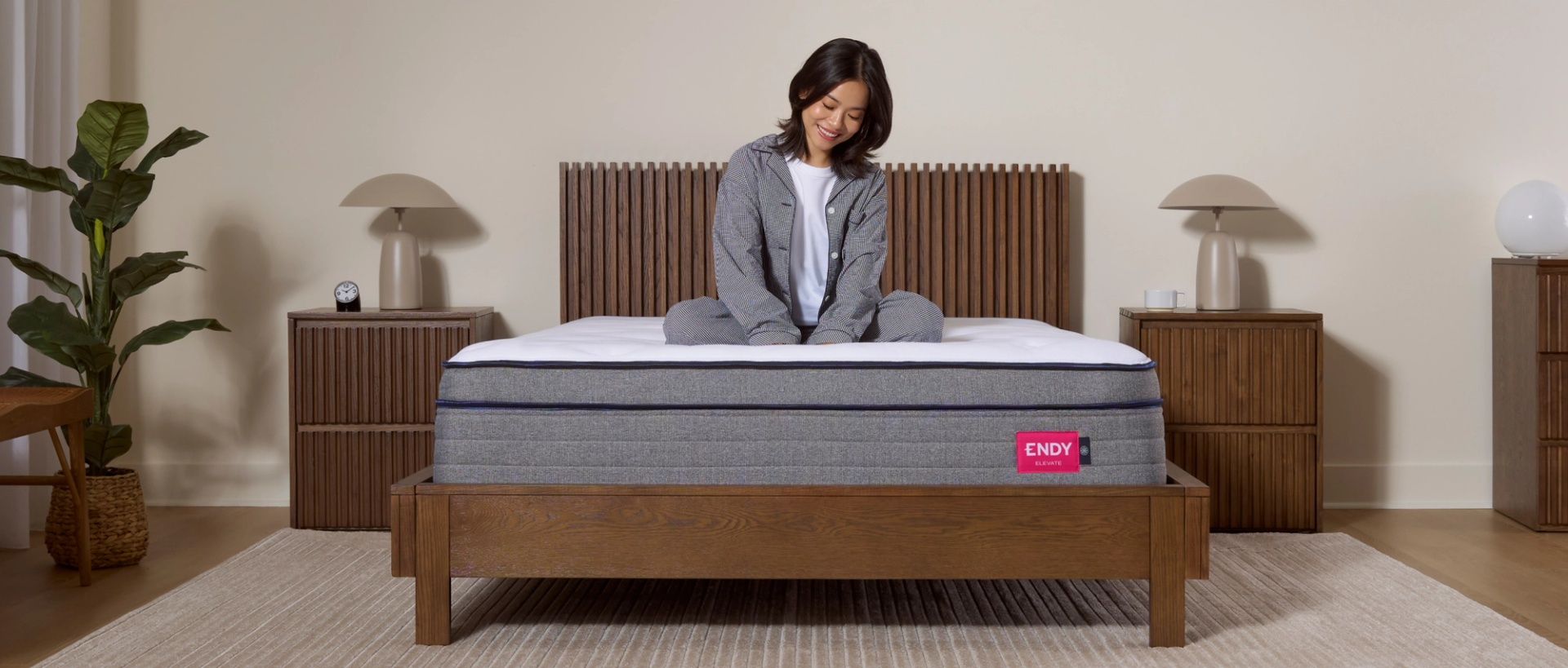 A woman sitting cross-legged on the Endy Elevate Hybrid Mattress